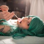 Фото татуировки на груди: розовый цветок с зелеными листьями, выполненный в акварельном стиле, нежный и романтичный рисунок.