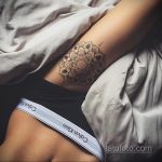 Фото тату мандалы на боку девушки. Черно-белая татуировка выполнена в геометрическом стиле с высокой детализацией. Девушка позирует в белье.