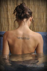 Фото тату на спине: вдохновляющая надпись 'I'm the hero of this story. I don't need to be saved.' выполнена черными чернилами. Мотивационный рисунок татуировки.