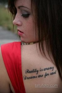 Фото тату на шее: надпись "Reality is wrong Dreams are for real", выполненная каллиграфическим шрифтом. Минималистичный и стильный эскиз тату.