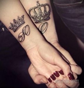 Фото парных татуировок на запястьях: черные короны с инициалами 'R' и 'L'. Детализированный дизайн и элегантный стиль.
