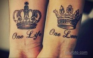 Фото парных татуировок: две короны с надписью 'One Life One Love' на запястьях. Детализированный рисунок татуировки, выполненный в черно-серых тонах.