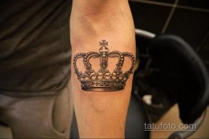 Фото тату короны в стиле Blackwork на предплечье. Детализированный рисунок татуировки с четкими линиями и глубоким черным цветом.