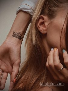 Фото тату маленькой короны на запястье. Черно-белый рисунок татуировки в минималистичном стиле.