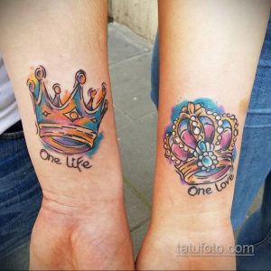 Фото парных татуировок с изображением акварельных корон и надписи 'One Life' на запястьях. Тату выполнены в ярких, пастельных тонах.
