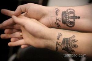 Фото тату: Две одинаковые татуировки короны с надписью 'One Life, One Queen' на запястьях двух людей. Символ любви и уважения.