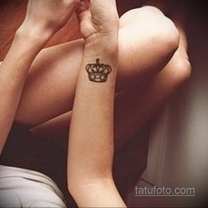 Фото тату маленькой черной короны на пальце. Изящный рисунок татуировки, выполненный в минималистичном стиле, подходит для тех, кто ценит сдержанность.