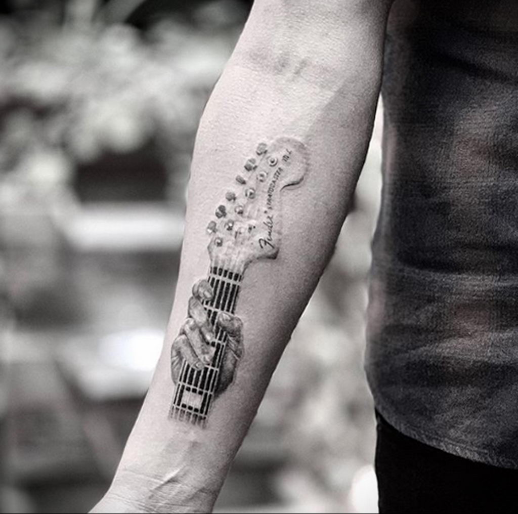 Необычная тату на тему дерева и гитары.