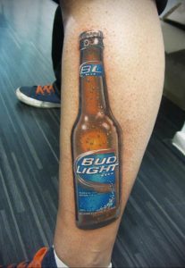 Фото тату на ноге с изображением бутылки пива Bud Light. Детализированный и реалистичный рисунок татуировки с каплями воды.