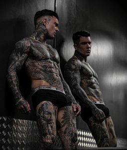 Фото тату на теле мужчины, демонстрирующее сложный рисунок в стиле blackwork и геометрия. Отражение в зеркале добавляет глубину и интерес к композиции.