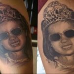 Фото тату на предплечье с изображением портрета маленькой девочки в короне и солнцезащитных очках. Выполнено в реалистичном стиле с использованием черно-белой гаммы.