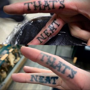 Фото тату: небольшая татуировка с надписью "That's Neat" на пальцах. Минималистичный и оригинальный дизайн.