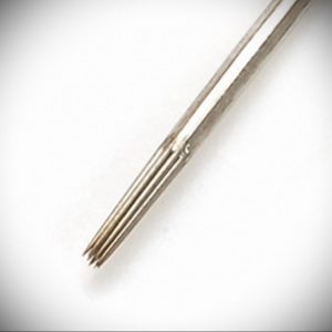 Крупный план стерильной тату-иглы с острым кончиком. Игла изготовлена из нержавеющей стали и предназначена для нанесения контуров татуировки.
