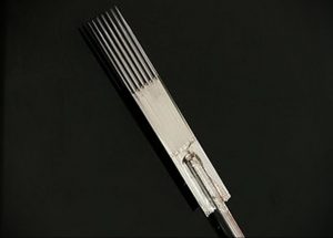 Крупный план стерильной иглы для татуировки в прозрачном пластиковом корпусе. Серебристая игла на черном фоне, акцент на стерильности и готовности к использованию.