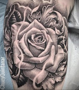 Фото тату: черно-белая татуировка розы на руке, выполненная в стиле blackwork. Детализированная прорисовка лепестков и листьев, использование точек и линий.