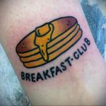 Фото тату блинчиков с надписью "Breakfast Club" на руке. Простой рисунок татуировки в минималистичном стиле.