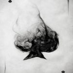 Фото тату: карта Ace of Spades, созданная из клубов дыма, выполненная в черно-белой гамме с эффектом размытости.