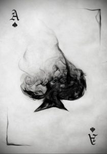 Фото тату: карта Ace of Spades, созданная из клубов дыма, выполненная в черно-белой гамме с эффектом размытости.