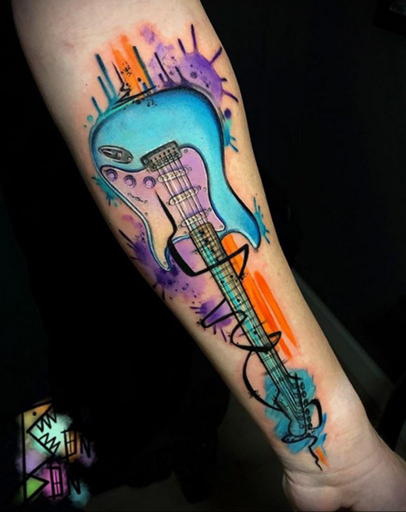 Яркая и цветная тату с гитарой и размытыми красками на руку - фото