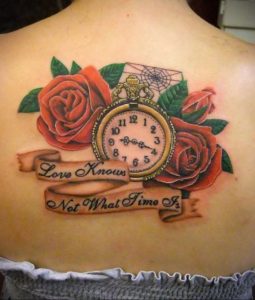 Фото тату на спине: яркие красные розы, карманные часы и надпись "Love Knows Not What Time Is", выполненные в реалистичном стиле.