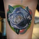 Фото тату: Серая роза на руке с реалистичными листьями. Детальная проработка, игра света и тени. Идеально для любителей классических татуировок.