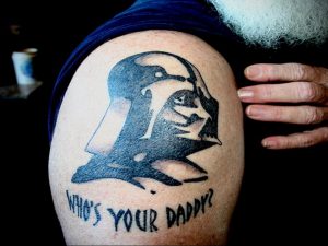 Фото тату Дарта Вейдера на плече с надписью 'Who's Your Daddy?'. Черно-белый рисунок в минималистичном стиле.
