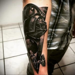 Фото тату Дарта Вейдера и истребителя TIE Fighter на руке, выполненное в черно-белой гамме с использованием эффекта брызг.