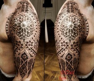 Фото тату: Мужчина демонстрирует впечатляющую татуировку в стиле орнамент, покрывающую большую часть плеча и верхней части руки. Четкие линии и сложные узоры.