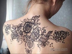 Фото тату хной на плече, сложный цветочный узор, восточный стиль, коричневые тона, детальная проработка лепестков и листьев.