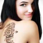 Фото тату мехенди на плече. Рисунок выполнен в коричневых тонах с использованием цветочных мотивов и ажурных узоров, создающих эффект кружева.