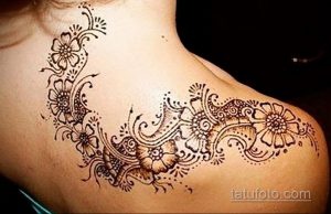 Фото тату мехенди на плече. Изящная цветочная композиция, выполненная в технике мехенди с использованием темной хны и тонких линий.