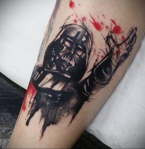 Фото татуировки в стиле splash ink с изображением Дарта Вейдера. Черно-белая графика, брызги краски и динамичная композиция.