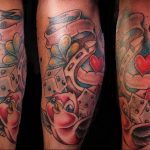 Фото тату подковы с игральными костями, клевером и сердцем. Рисунок татуировки в стиле олдскул с использованием красного, голубого и черного цветов.