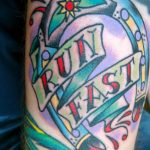 Фото тату на руке: подкова с надписью 'RUN FAST', выполненная в ярких и насыщенных цветах. Динамичный и мотивирующий рисунок татуировки.