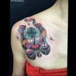Фото тату с изображением игральных костей, клевера и надписью 'Luck'. Традиционный стиль, яркие цвета, плечо.