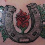 Фото тату розы и подковы на коже. Красочный рисунок татуировки с детальной проработкой цветов и элементов.