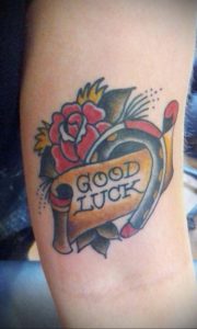 Фото тату подковы с розой и надписью "GOOD LUCK" в стиле олдскул. Яркие цвета и четкие линии.