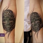 Фото тату Дарта Вейдера в стиле трайбл на предплечье. Черно-серые тона, детализированный рисунок шлема и узоры вокруг.