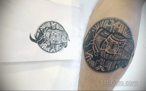 Фотография трайбл татуировки носорога, заключенного в круг. Черно-белый рисунок с использованием традиционных полинезийских узоров.