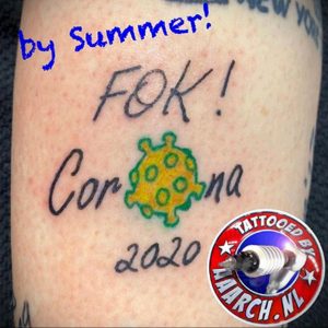 Татуировка с надписью "F*ck Corona 2020" и изображением вируса COVID-19, выражающая протест и недовольство пандемией.
