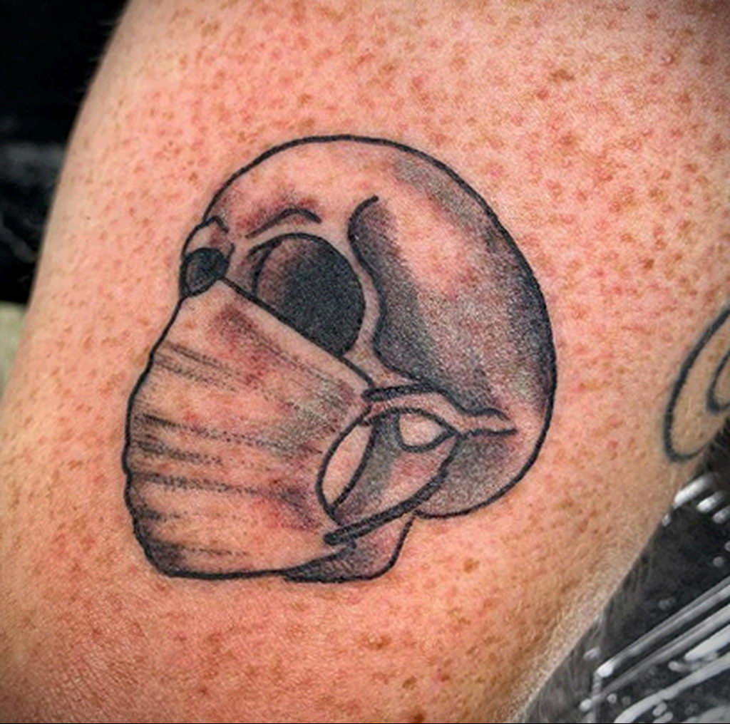 Татуировка на тему коронавируса COVID-19 - череп в одноразовой медицинской маске