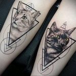 Фото тату двух кошек, выполненное в стиле геометрии на ногах. Рисунок состоит из треугольников и линий, создающих абстрактное изображение кошачьих голов.