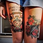 Фото тату на бедрах: винтажный телефонный аппарат с трубкой, украшенный яркими цветами и надписью. Детализированный рисунок в стиле олд скул.