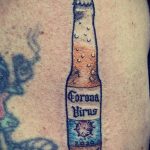 Фотография небольшого тату на руке с изображением бутылки пива Corona с надписью 'Corona Virus' и годом 2020.