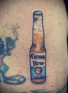 Фотография небольшого тату на руке с изображением бутылки пива Corona с надписью 'Corona Virus' и годом 2020.