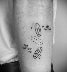 Фото тату на руке с изображением инструкции "Get Tattoo". Минималистичный стиль и юмористический дизайн.