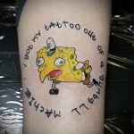 Фото тату с изображением Губки Боба в круге с надписью 'I GOT MY TATTOO OUT OF A MACHINE'. Веселый и яркий рисунок на руке.