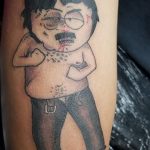 Фото тату: яркий рисунок персонажа Картмана из мультсериала South Park, изображенного в характерной позе с поднятой рукой и кровоточащим лицом.