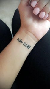 Фото татуировки на запястье с надписью "luke 22:42". Черный цвет, тонкие линии, религиозная тематика. Минималистичный и значимый рисунок.