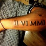 Фото тату: татуировка римскими цифрами 'II VI MMI' на запястье. Черный цвет, четкие линии, минималистичный дизайн.